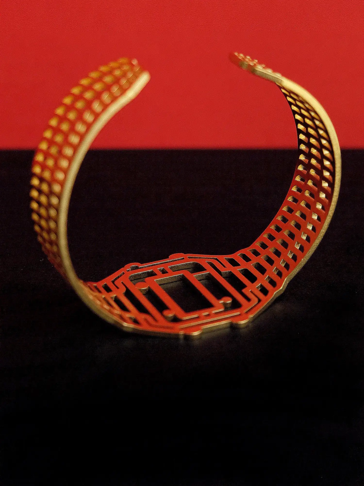 Golden TIMEPEACE bracelet, minimalist design, watch-inspired timepiece jewelry from backside against black and red background