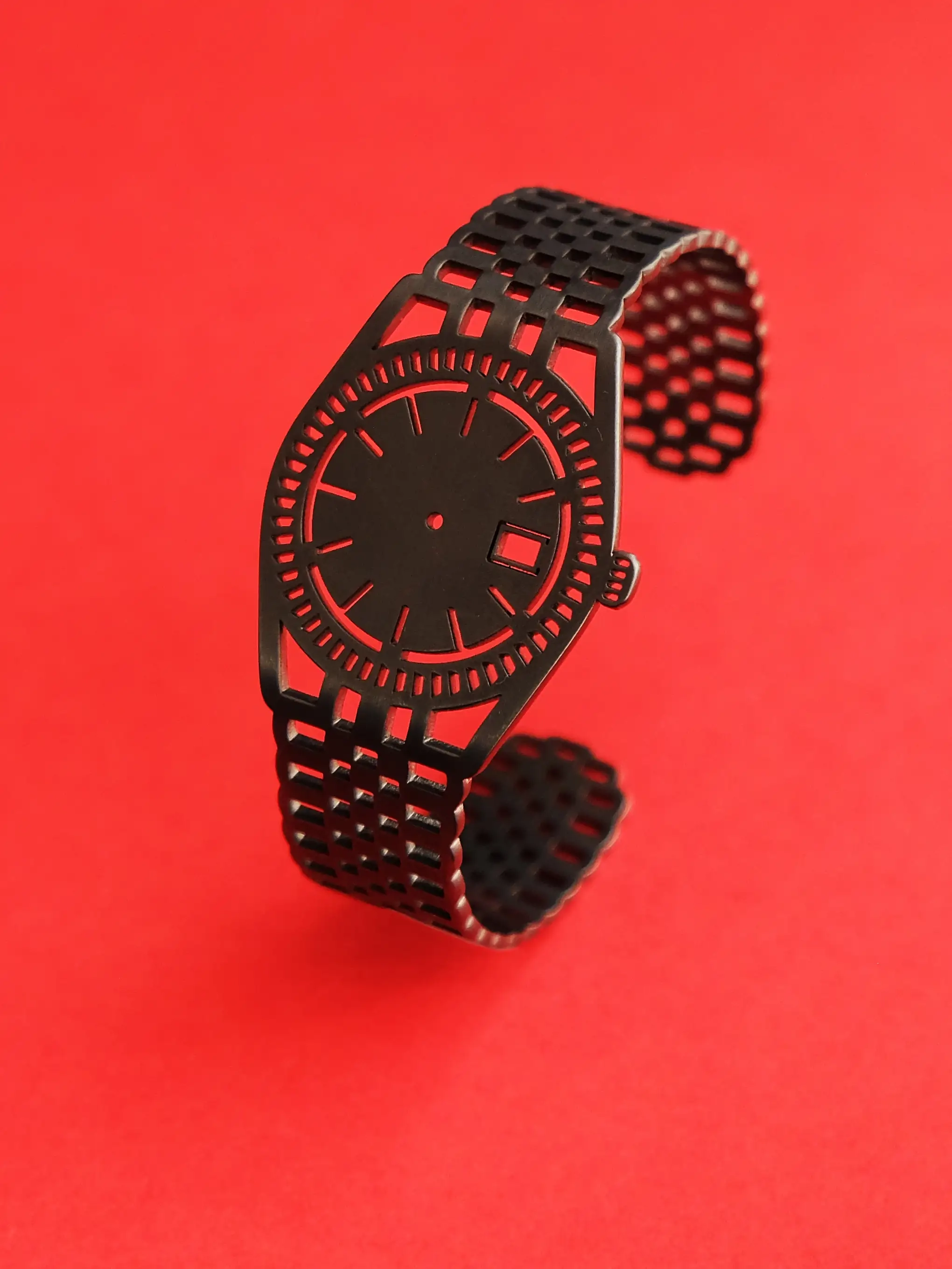 High-quality stainless steel TIMEPEACE bracelet showing small details of the design, dark grey ruthenium finish, on a red background