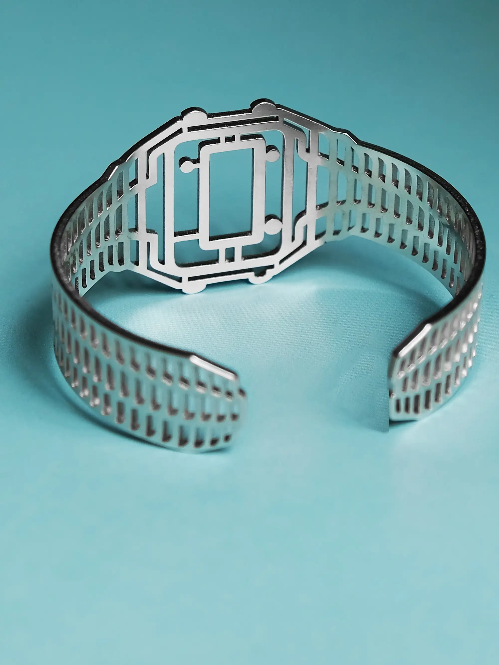 Silver TIMEPEACE bracelet, minimalist design, watch-inspired timepiece jewelry from backside on blue background