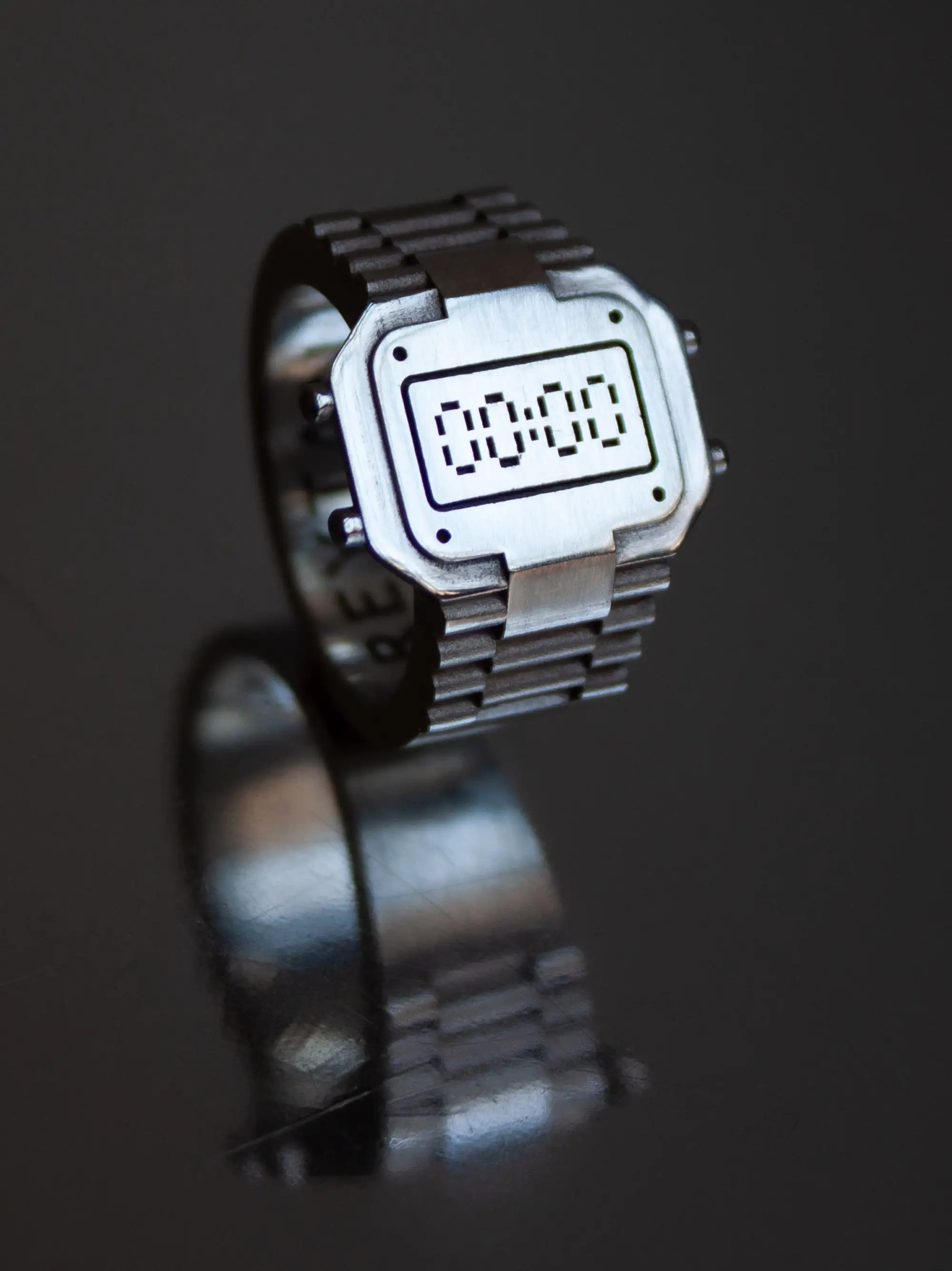 Silver TIMEPEACE watchring, minimalist clock-inspired ring without time display representing restart and reset, on shiny silver background