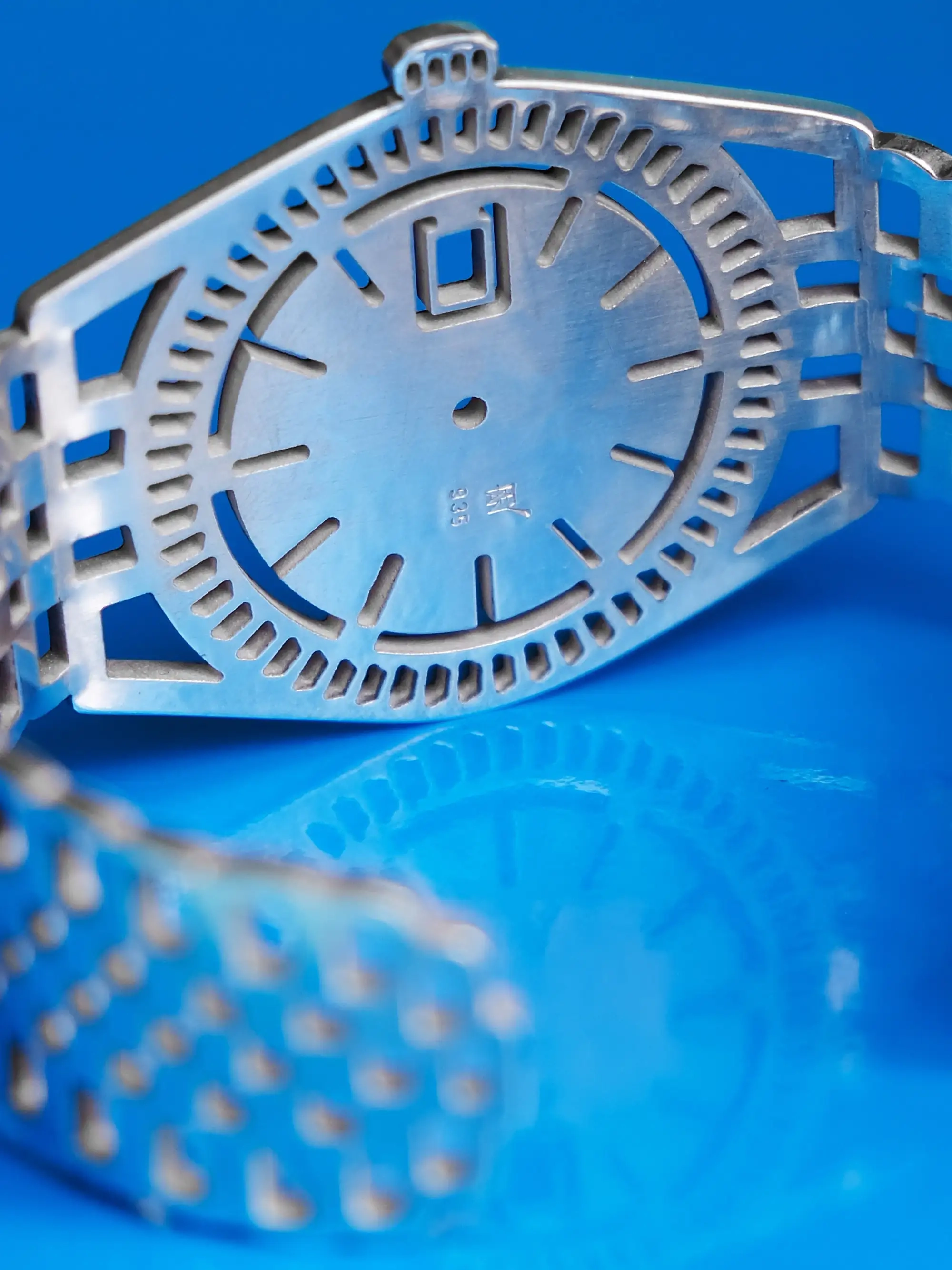 Detail view of sterling silver TIMEPEACE bracelet, watch-inspired jewelry with cut-out links and engraved logo and 925 silver stamp